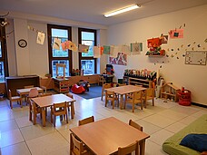 Gruppenraum mit kleinen Tischen und Sesseln