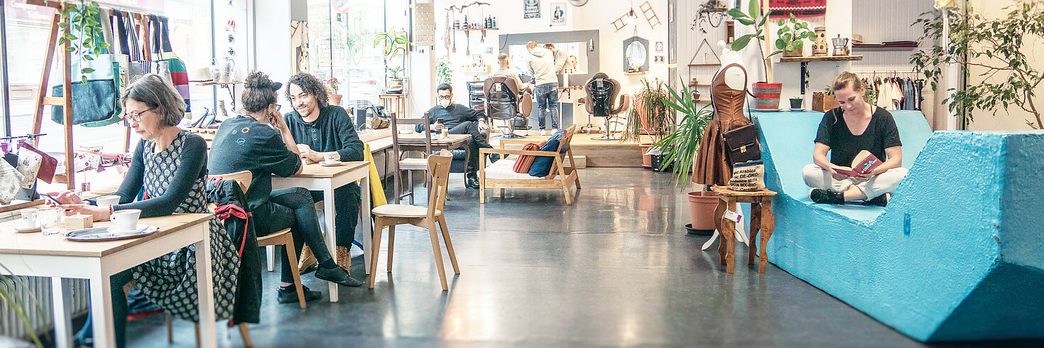 Menschen sitzen im Baharat, unterhalten sich, trinken Kaffee oder lesen