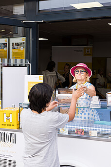 Eine Frau gibt einer anderen Frau ein Eis in der Waffel.
