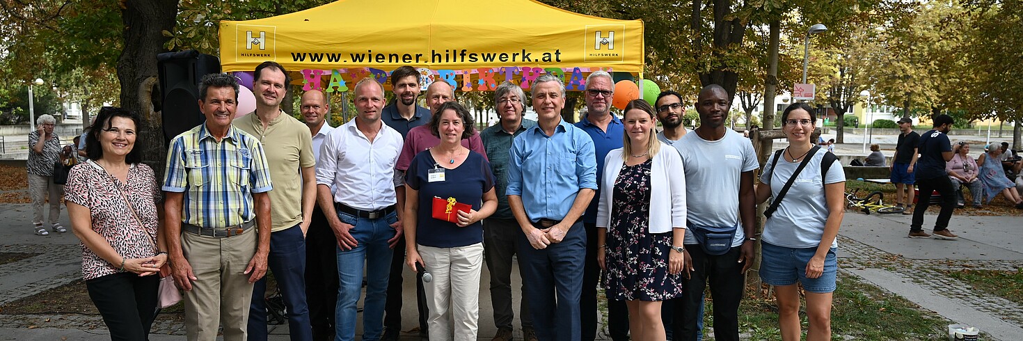 Gruppenfoto im Park im Hintergrund ein gelbes Zelt