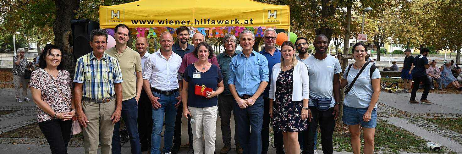 Gruppenfoto im Park im Hintergrund ein gelbes Zelt