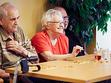 Gäste des Tageszentrum sitzen am Tisch und spielen